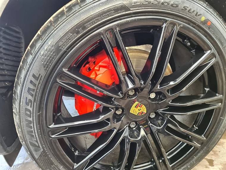 A refurbished gloss-black alloy wheel with red brake calipers
