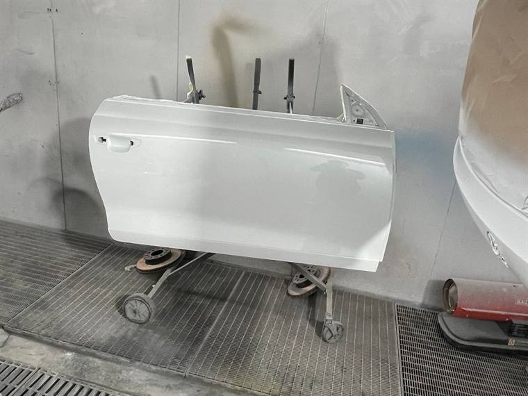 A white door on a stand inside the spray booth