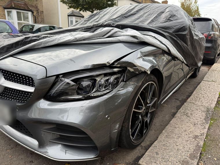 Grey Mercedes-Benz C-Class with the front wing, bumper and headlight crushed after a collision