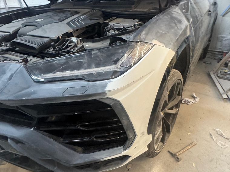 Black Lamborghini Urus on the ramp with the front wing rebuilt and in primer
